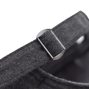 Macro view of adjustable silver metal buckle and washed grey fabric texture on baseball cap