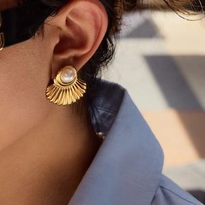 18K gold stainless steel fan-shaped earrings with white pearl on a model's ear