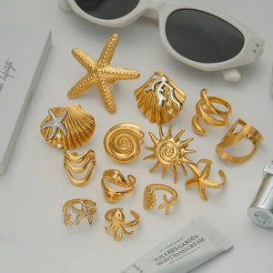 Flat lay of gold ocean themed rings with starfish shell octopus and pearl details