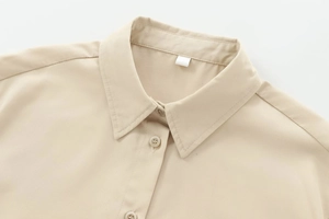 Detail of lapel collar and round buttons on apricot long sleeve twill shirt