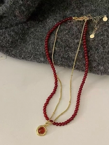 Close-up of double-layer tiger eye beaded necklace with retro gold pendant and red gemstone