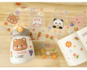 Close-up of waterproof cartoon animal stickers applied to a white stainless steel water bottle