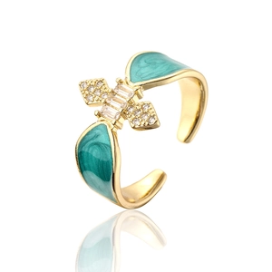 Detail of 18K gold plated ring featuring green enamel wings and micro-inset cubic zirconia