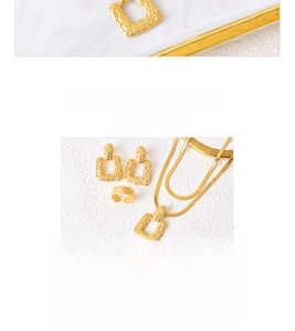 Detail of gold titanium jewelry set featuring hammered texture earrings, necklace, and ring