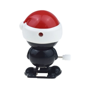 Cute wind-up walking penguin toy with Christmas hat on a clean white background