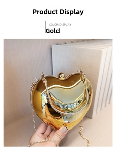 Detail of a gold heart-shaped evening bag with a metallic mirror finish and chain strap
