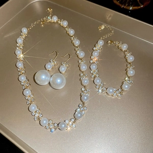 Vista dettagliata del set di gioielli con perle, collana a fiori, bracciale e orecchini