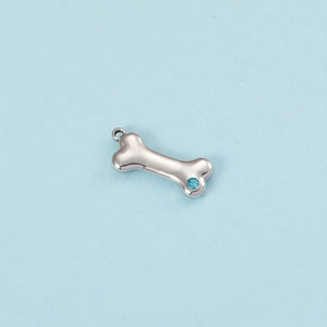Detailed view of silver bone pendant with blue crystal on a light blue background