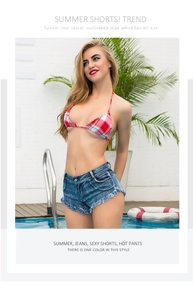 Detail von dunkelblauen Denim-Minishorts mit Bikinioberteil am Sommerpool gezeigt