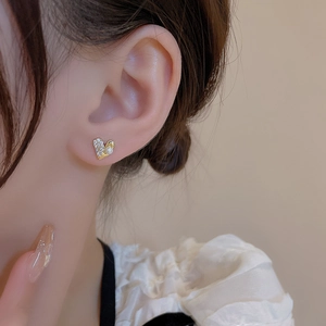 Elegant heart earrings with gold frame, micro-set diamonds and pearl on model