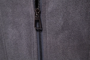 Macro shot of durable metal zipper with triangular puller on suede jacket fabric