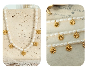 Close-up of natural freshwater pearls necklace featuring golden daisy flower pendants