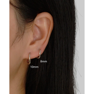Close-up of 925 silver irregular wave hoop earrings in 8mm and 10mm sizes worn on ear