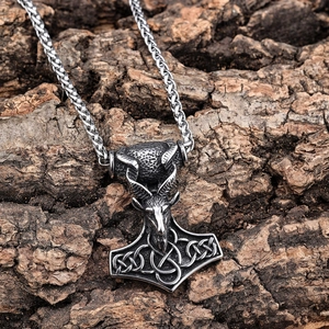 Vintage Thor's Hammer pendant with ram head in stainless steel on a rustic bark background