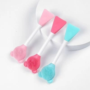 Three dual-ended silicone face mask brushes with bear shaped heads in pink and blue