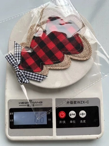 Detail of red and black plaid Christmas cutlery holder with bow decoration on a scale