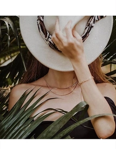 Close-up of double-layered rose gold snake chain necklace on model in sunlight