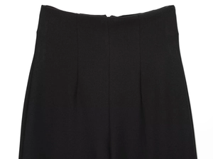 Détails du pantalon noir à taille haute montrant la texture du tissu et la couture taille