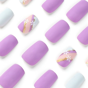 Blue and purple matte press-on nails with white floral art and gold foil accents