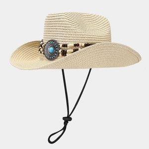 Close-up of woven straw hat with ethnic beaded band and turquoise metal emblem detail