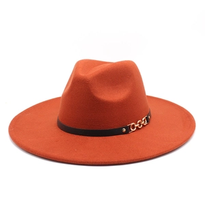 Close-up of orange wool fedora featuring a black leather band and gold metal chain buckle