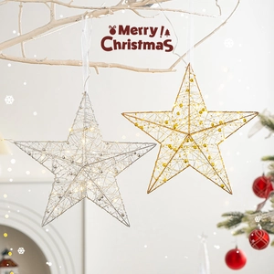 Stelle di Natale in metallo oro e argento appese ai rami per decorazioni d'interni
