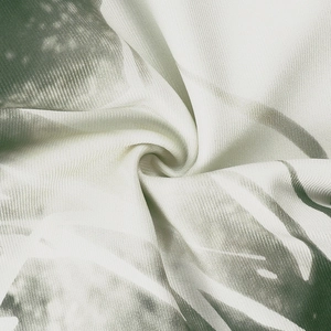Close-up of white and green abstract pattern on premium twill fabric with silky texture
