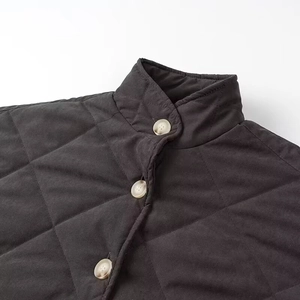 Close-up of a charcoal grey quilted jacket featuring a stand collar and button details