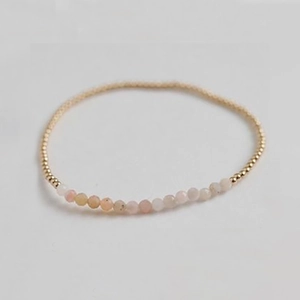 Macro view of handmade stretch bracelet with faceted amethyst and golden metal beads