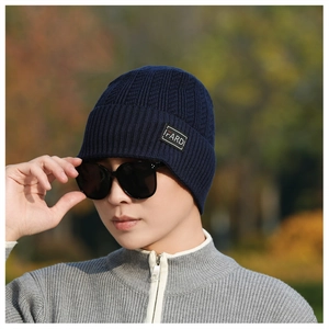Close-up of navy knit beanie texture and FARDI leather patch detail in autumn setting