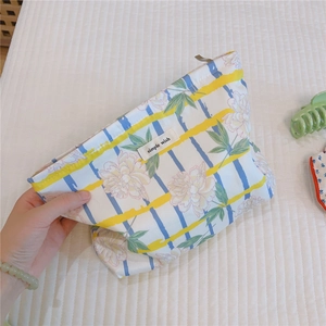 Detail of floral striped cotton makeup bag featuring the simple wish logo label