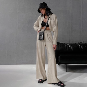 Detailed shot of beige cropped long-sleeve shirt and high-waist wide-leg pants set