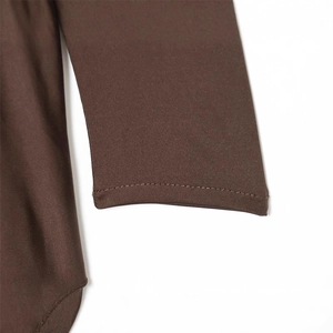 Close-up of brown knit dress sleeve showing detailed stitching and cuff craftsmanship