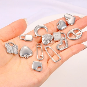 Handheld silver stainless steel charms featuring heart, moon, and lock designs for jewelry making