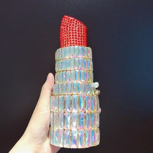 Detailed view of lipstick shaped evening clutch with red and AB color rhinestones