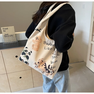 Close-up of cream canvas tote bag with cartoon koala, panda and tiger illustrations