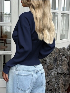 Rear view of navy blue ribbed knit sweater with waist-defining fit and long sleeves