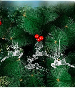 Detailed view of four transparent reindeer ornaments hanging on a green Christmas tree