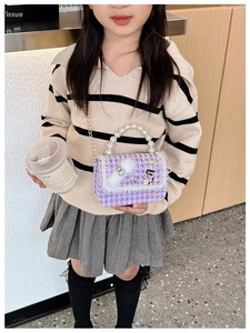 Detail of girls' purple houndstooth mini bag with pearl handle and golden chain strap