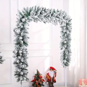 Flocked Christmas garland arch with white snow effect over green pine needles