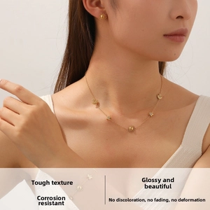 Detail of gold celestial jewelry set with sun, moon, and star pendants on a female model