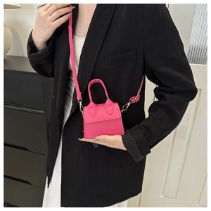 Minimalistische rosa PU-Leder-Quadrat-Tasche, getragen von einem Modell in schwarzem Blazer