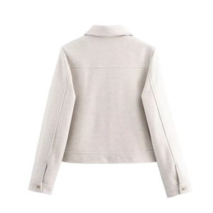 Detail view of the back of a beige cropped jacket with seam lines and collar detail