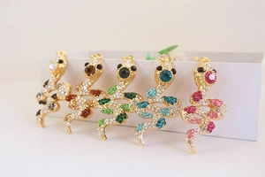 Five gold snake keychains with colorful rhinestones in pink, blue, green, brown, and black
