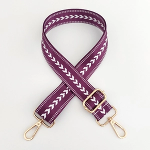 Detailed view of purple nylon strap with white arrow pattern and gold metal hardware