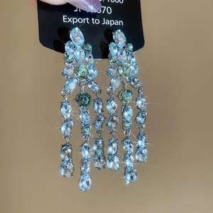 Vue macro des boucles d'oreilles à pampilles en argent avec cristaux bleu et vert