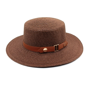 Detailed close-up of brown woven straw boater hat with leather band and golden buckle