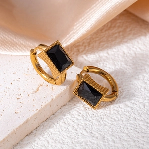 Detail of vintage gold star earrings featuring emerald-cut black zircon on stone base