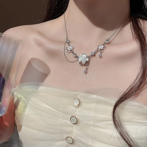 Detail of silver floral necklace featuring white pearl flower with sparkling zircons