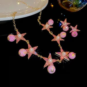 Pink star jewelry set with necklace and earrings featuring pearls and gold chains